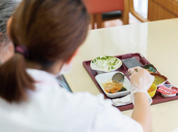 入居者様の食事を支援する施設スタッフ